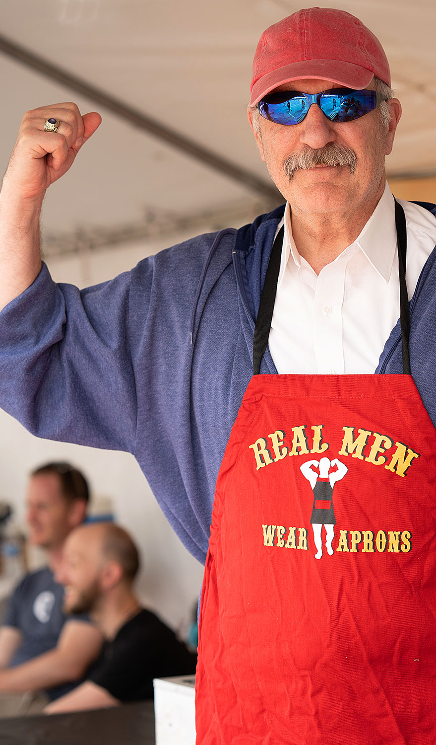 Restaurant owner in apron that displays "Real men wear aprons"